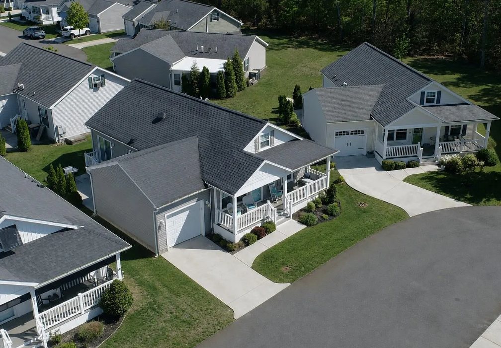 Aerial view of homes with porches and driveways along a curved street