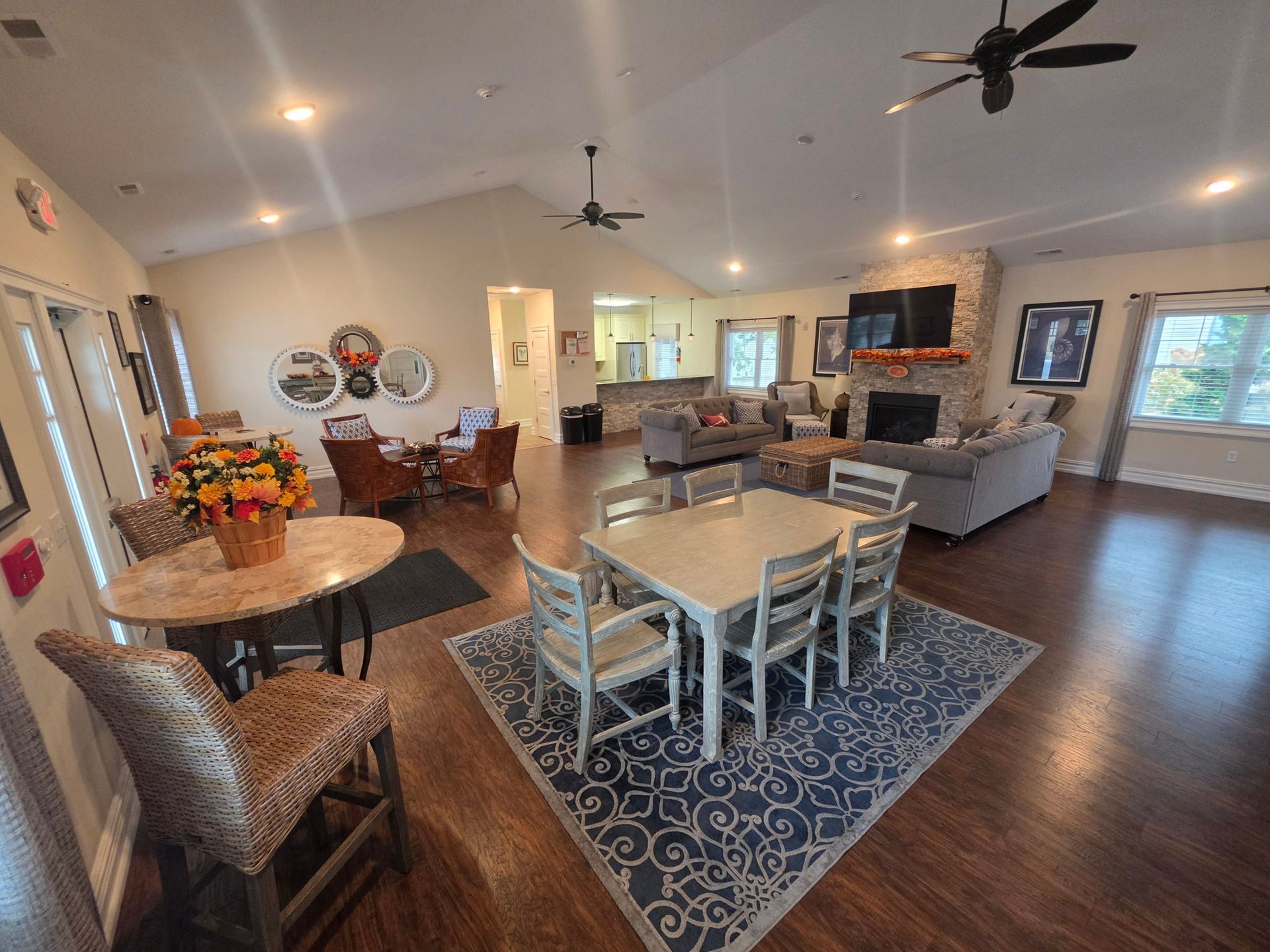 Clubhouse dining table, bistro tables and lounge seating beneath a vaulted ceiling