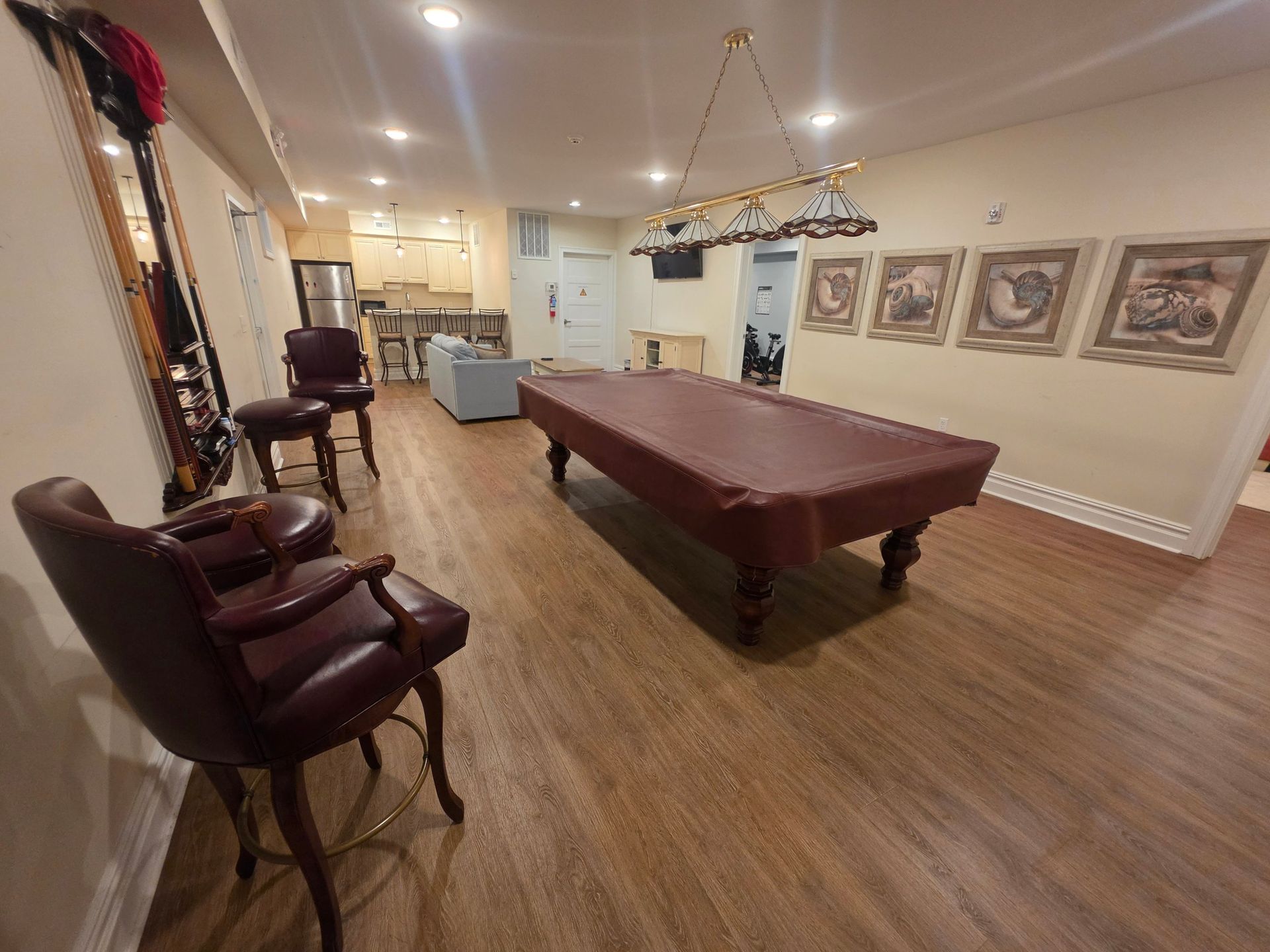 Game room with a billiard table, sofa seating and a kitchenette with bar stools